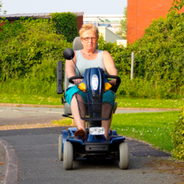 Woman riding outside in a mobility scooter