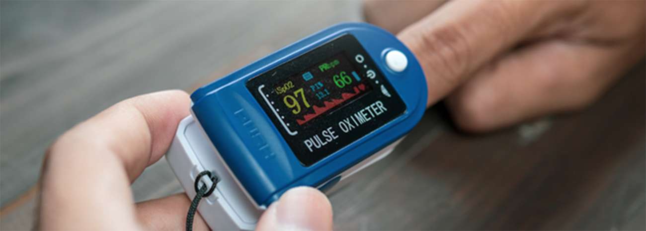 Person putting blue pulse oximeter on their finger