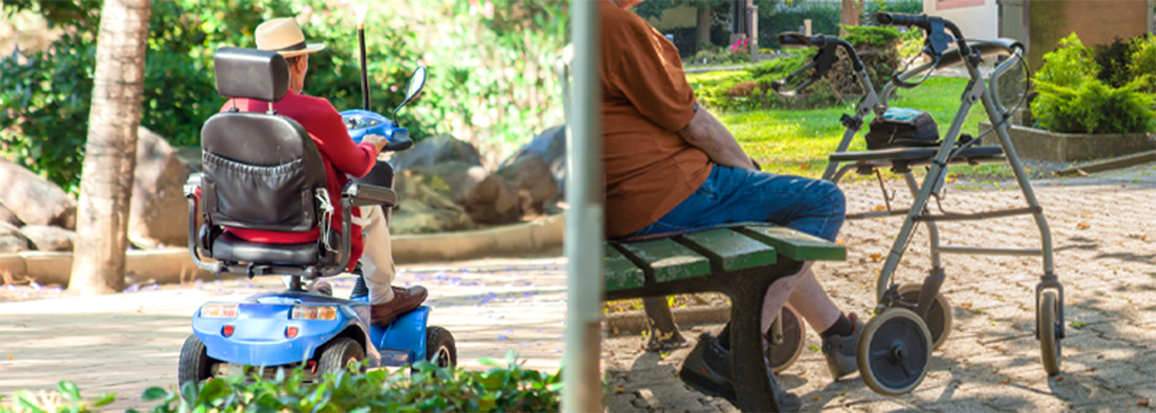 Older man in mobility scooter on the left, senior citizen sitting on bench with rollator in front of them on right