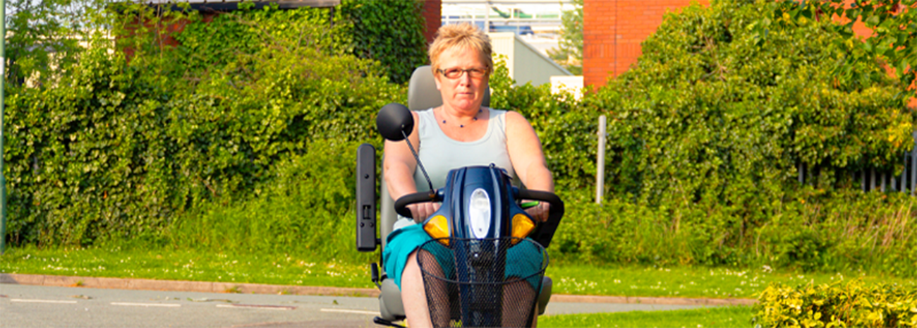 Woman riding outside in a mobility scooter