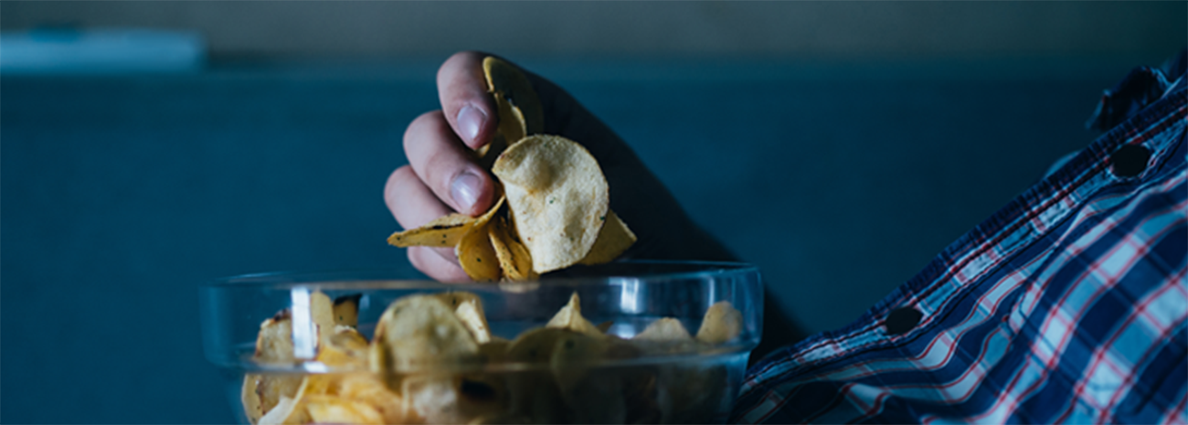 Close-up image of person holding bowl of potato chips