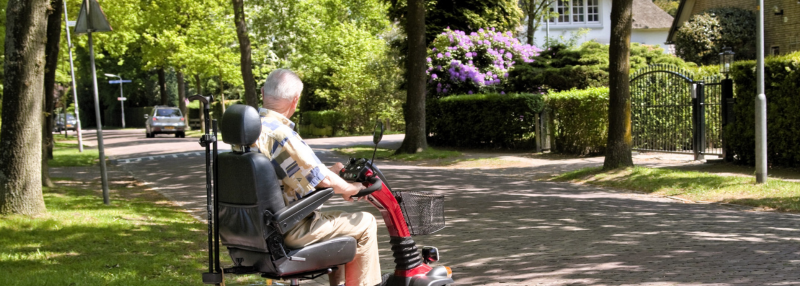 Senior man in mobility scooter crossing the street