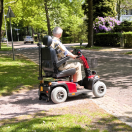 Senior man in mobility scooter crossing the street