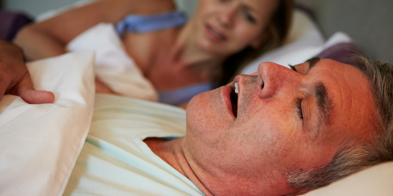 Photo of a man sleeping and looks like he is snoring.