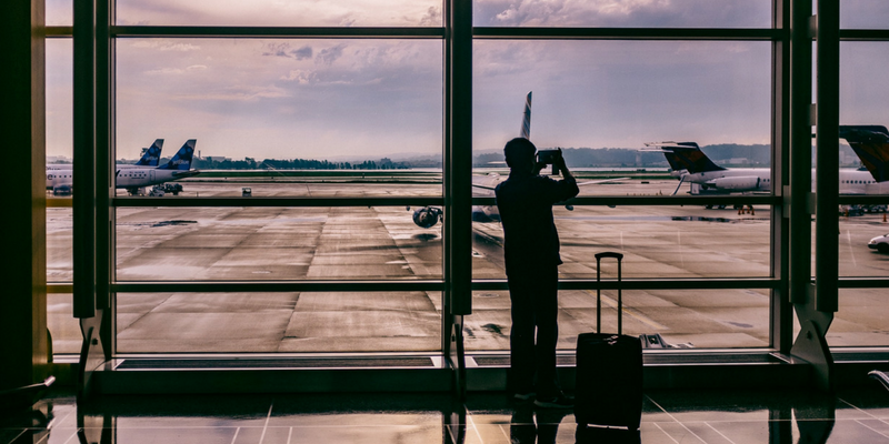 Photo of a person standing inside of an airport taking a photo.