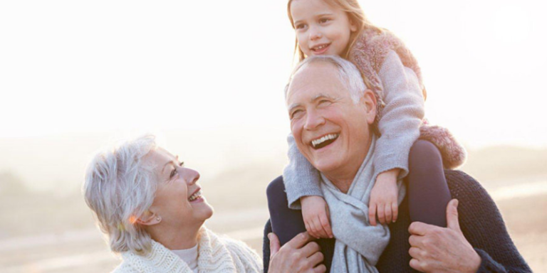 Photo of elderly couple outside with their grandchild.