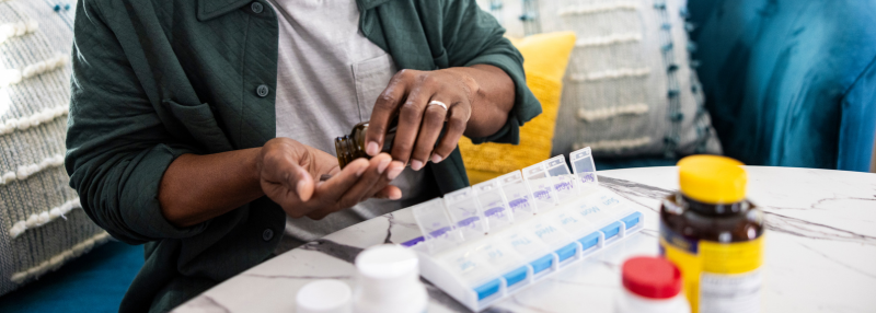 Man organizing his medications into a pill organizer