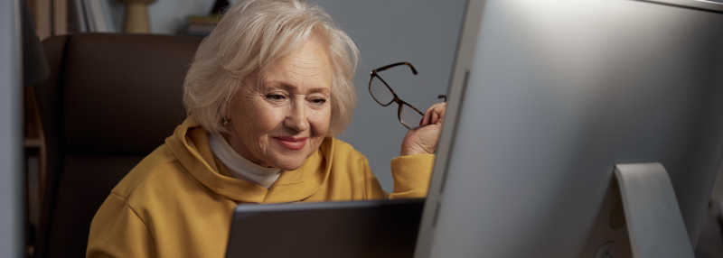 Older woman browsing on the computer at her desk