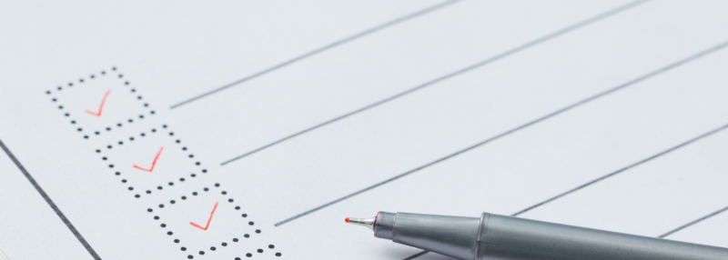 Checklist on clipboard with pen on it